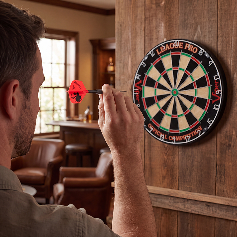 Man aiming a Laserdarts Black Widows Movable Point Smooth Steel Tip at a dartboard in a room with wooden walls and furniture.
