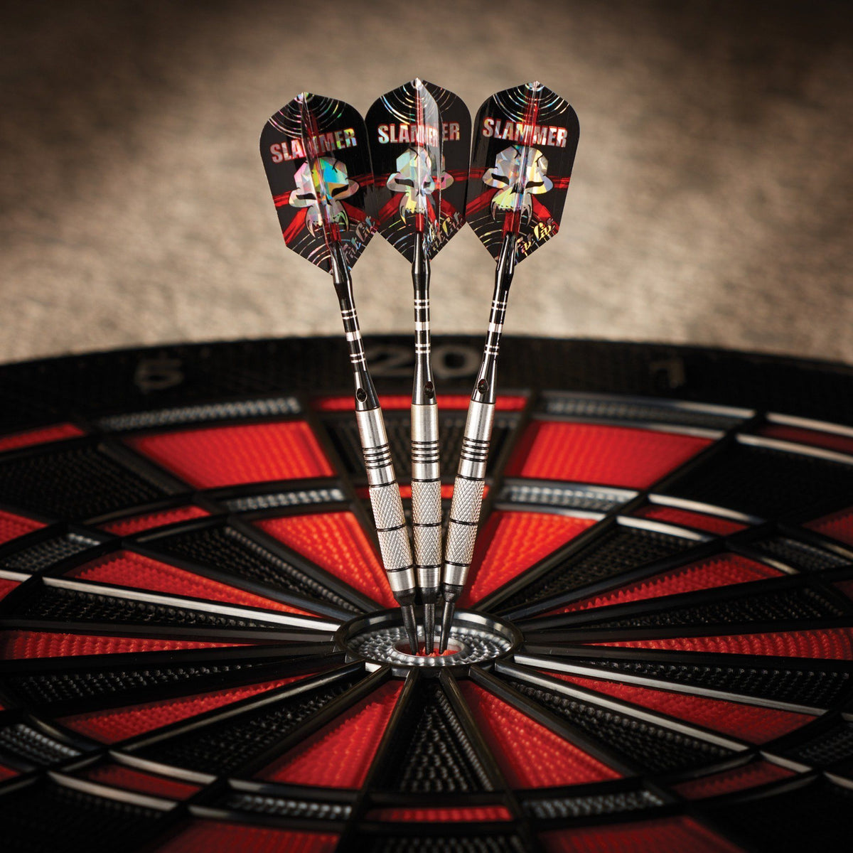 Three darts with black "Slammer" flights stuck in the center of a red and black dartboard