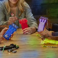 Three people at a table holding blue, red, and purple dart cases with darts