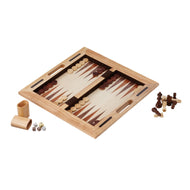 Wooden backgammon board with light and dark brown pieces, dice cup, dice, and chess pieces arranged beside it