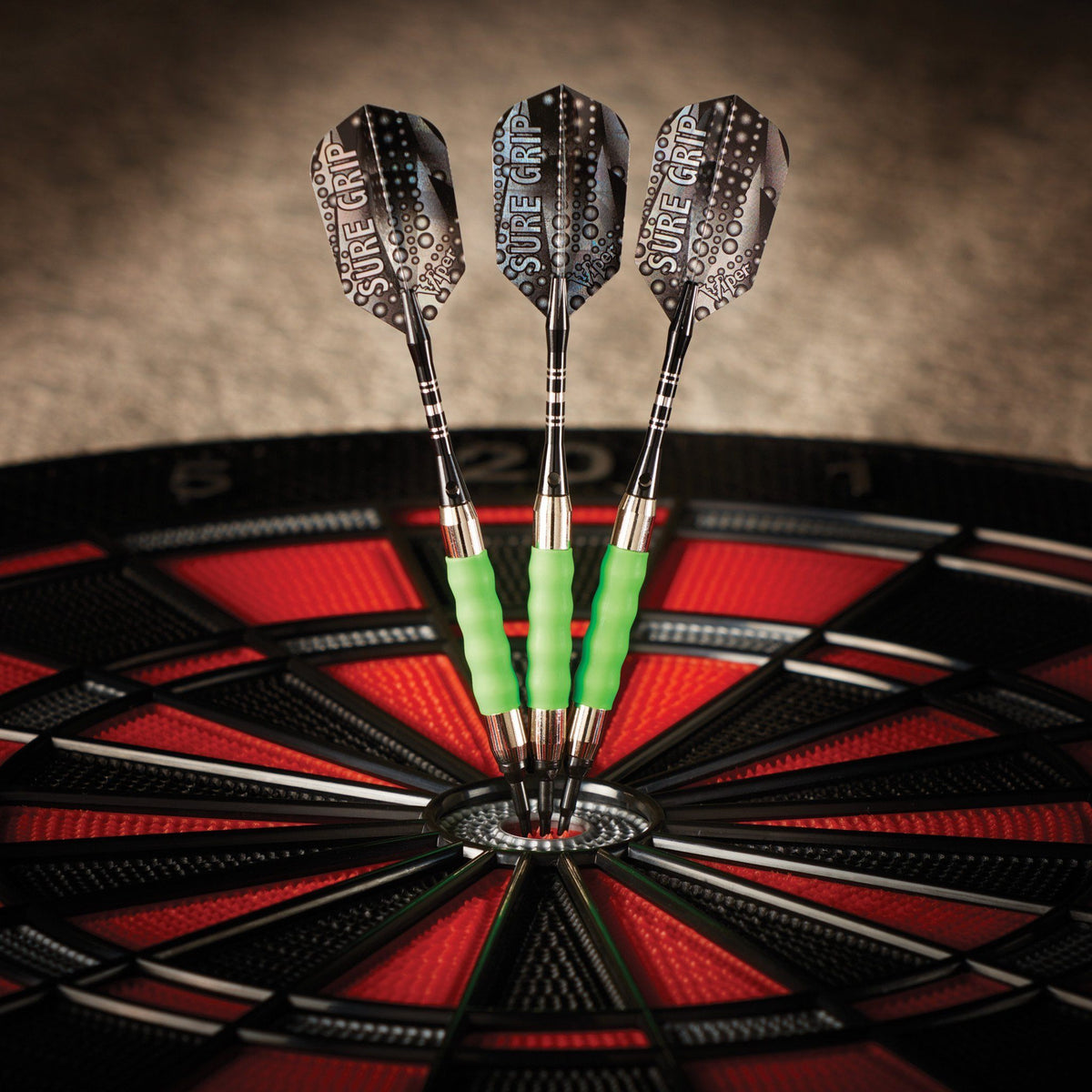 Three darts with green barrels and patterned flights in dartboard bullseye