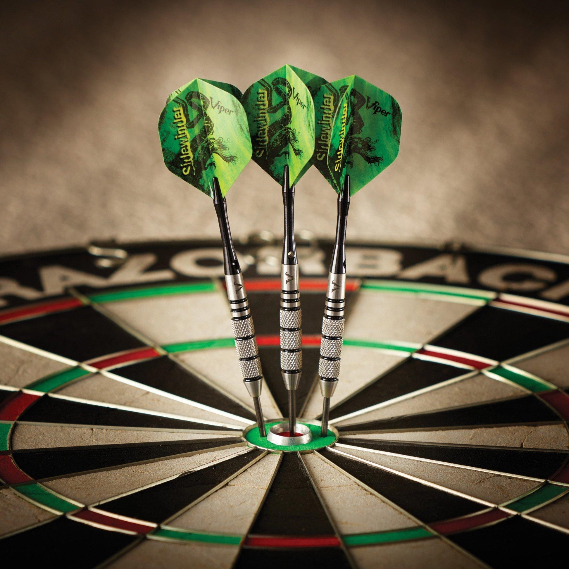 Three green-and-yellow Sidewinder darts with metal barrels embedded in a dartboard bullseye