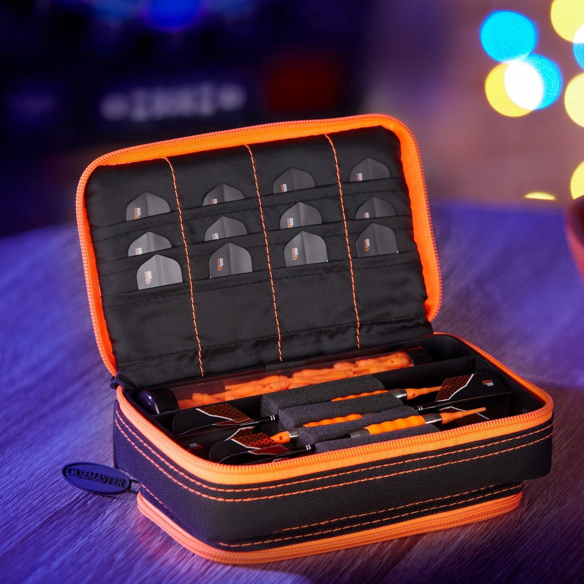 Orange and black dart case open showing dart slots and accessories compartment