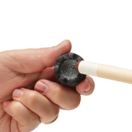 A person holds a cue stick tip with a black rubber ferrule containing gray abrasive chalk