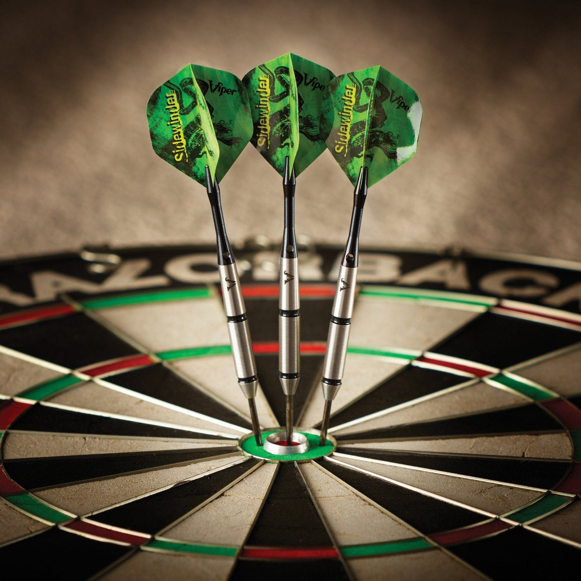 Three green Sidewinder darts stuck in the center of a dartboard