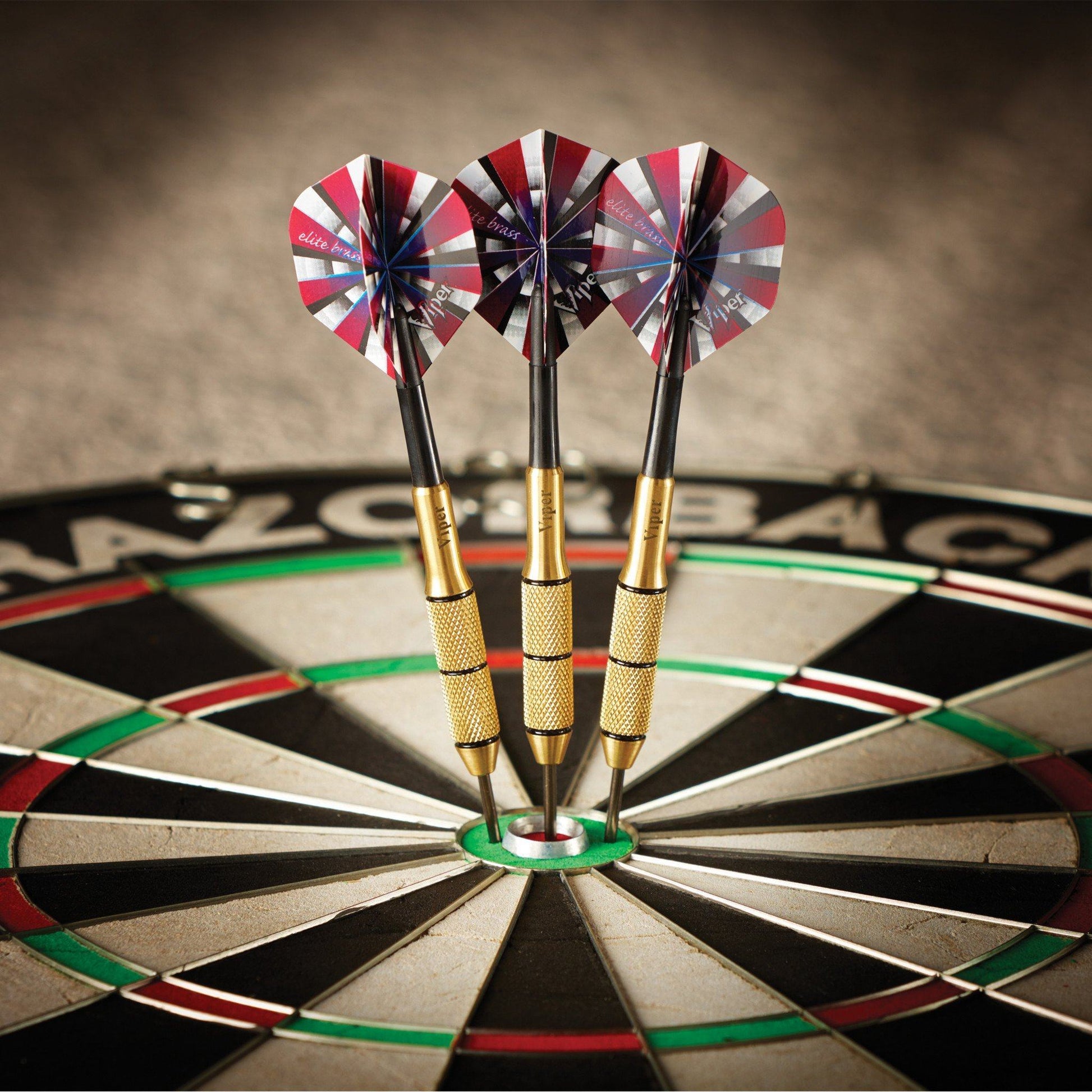 Three darts with red and white striped flights in a dartboard bullseye