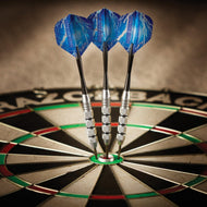 Three blue darts with silver barrels stuck in dartboard center bullseye