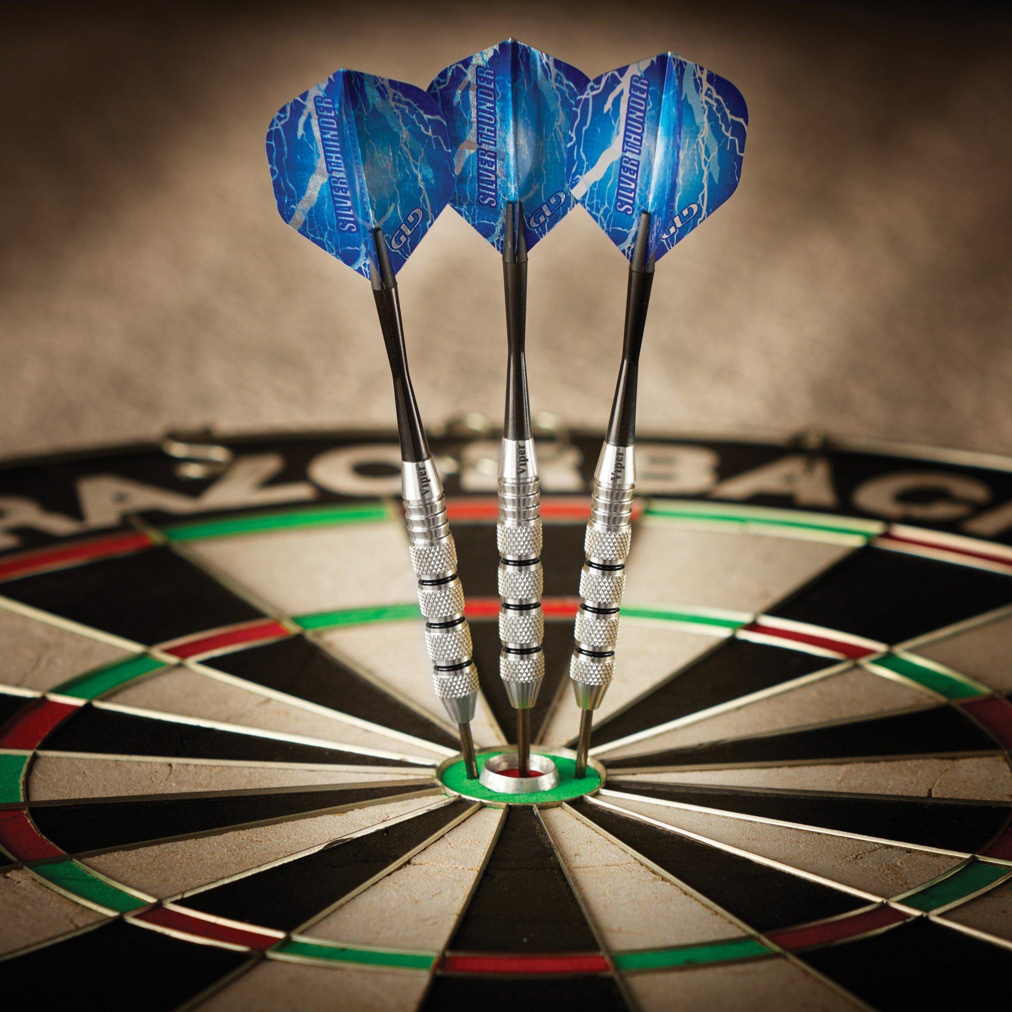 Three blue darts with silver barrels stuck in dartboard center bullseye