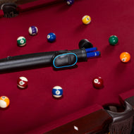 Black cue stick with blue accents on burgundy pool table with numbered balls