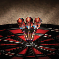 Three darts with red and blue flights in dartboard bullseye